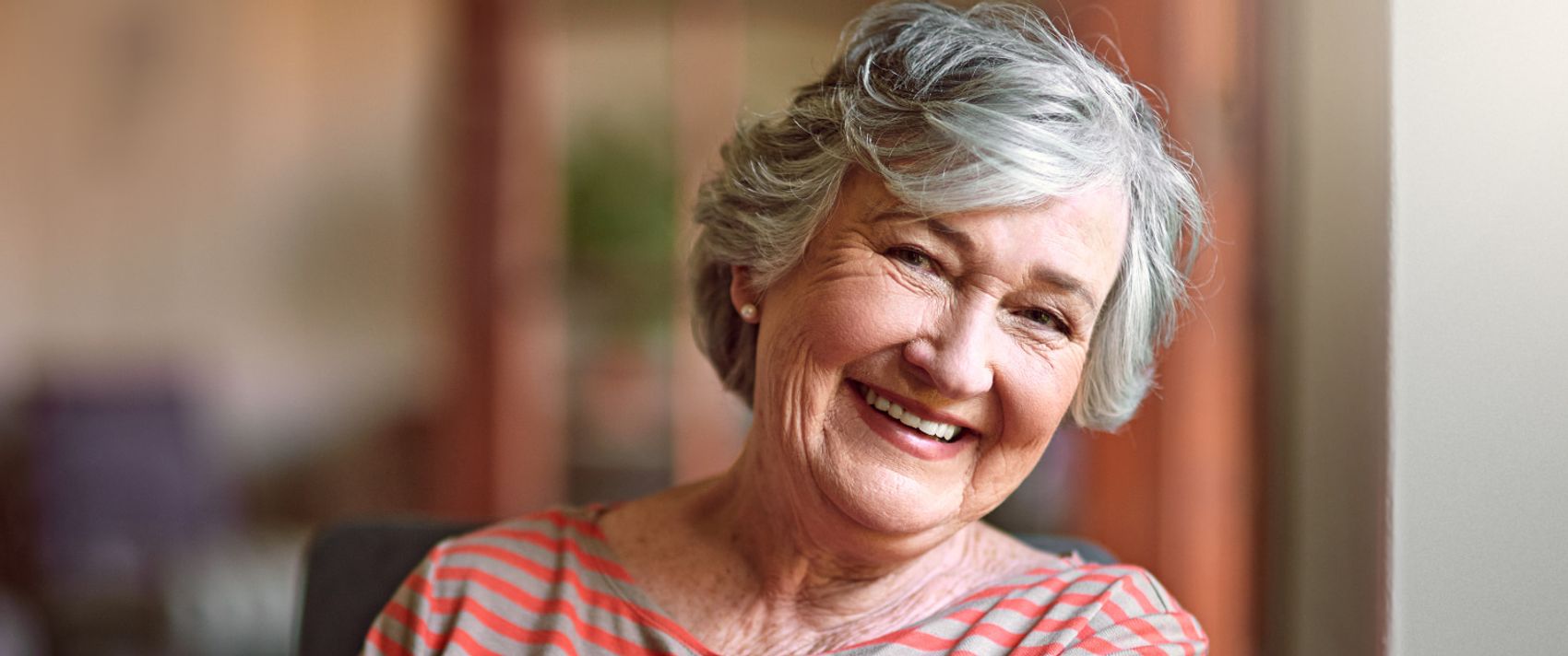 Eine Seniorin lächelt zufrieden.