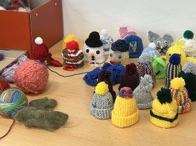 Ein Tisch voller Strickmützchen (Foto: Malteser Speyer)