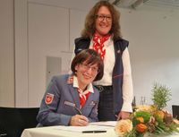 zwei Frauen bei einer Unterschrift am Tisch