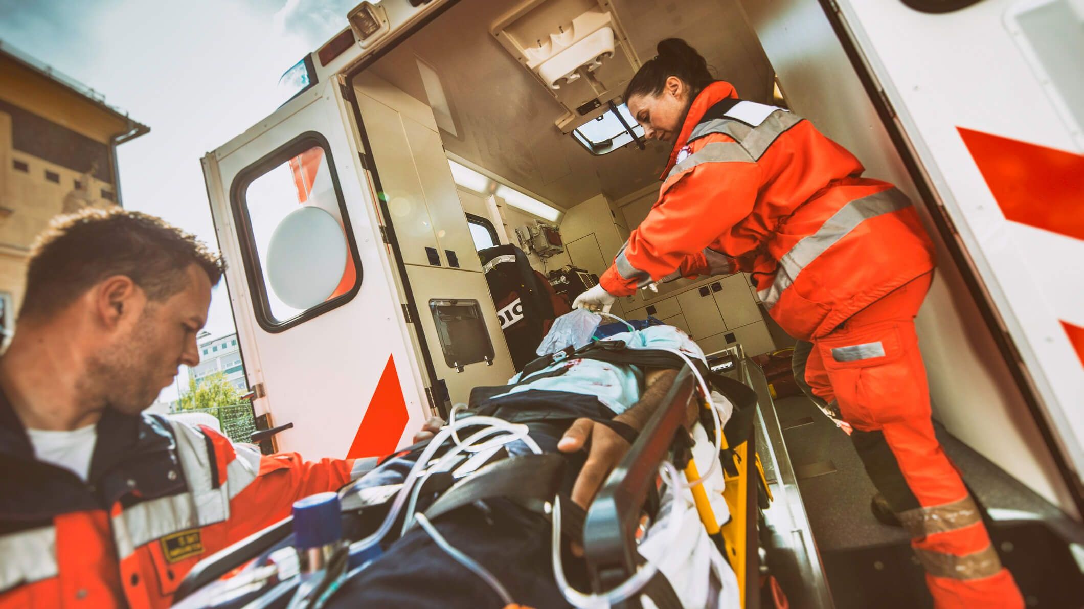 Zwei Rettungssanitäter transportieren einen Patienten in den Rettungswagen