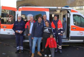 V.l.n.r.: Theo Söntgerath, Hans Schramm, Mario Dahm, Martin Rösler und Philip Kabus gemeinsam mit einer Besucherin und ihrem Sohn am Malteser-Stand beim Hennefer Stadtfest.