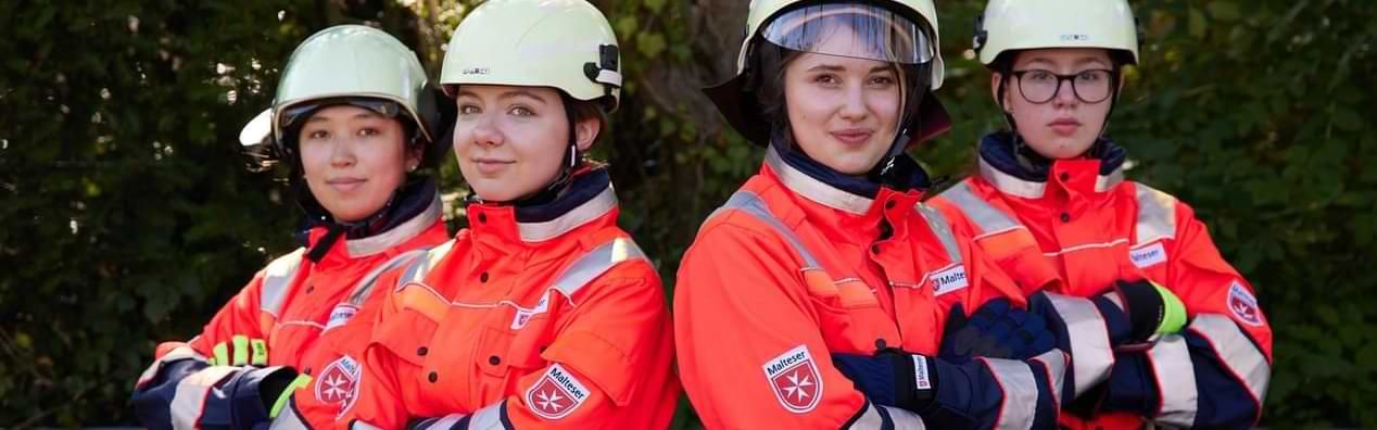 Vier junge Frauen in der Einsatzkleidung des Katastrophenschutzes.