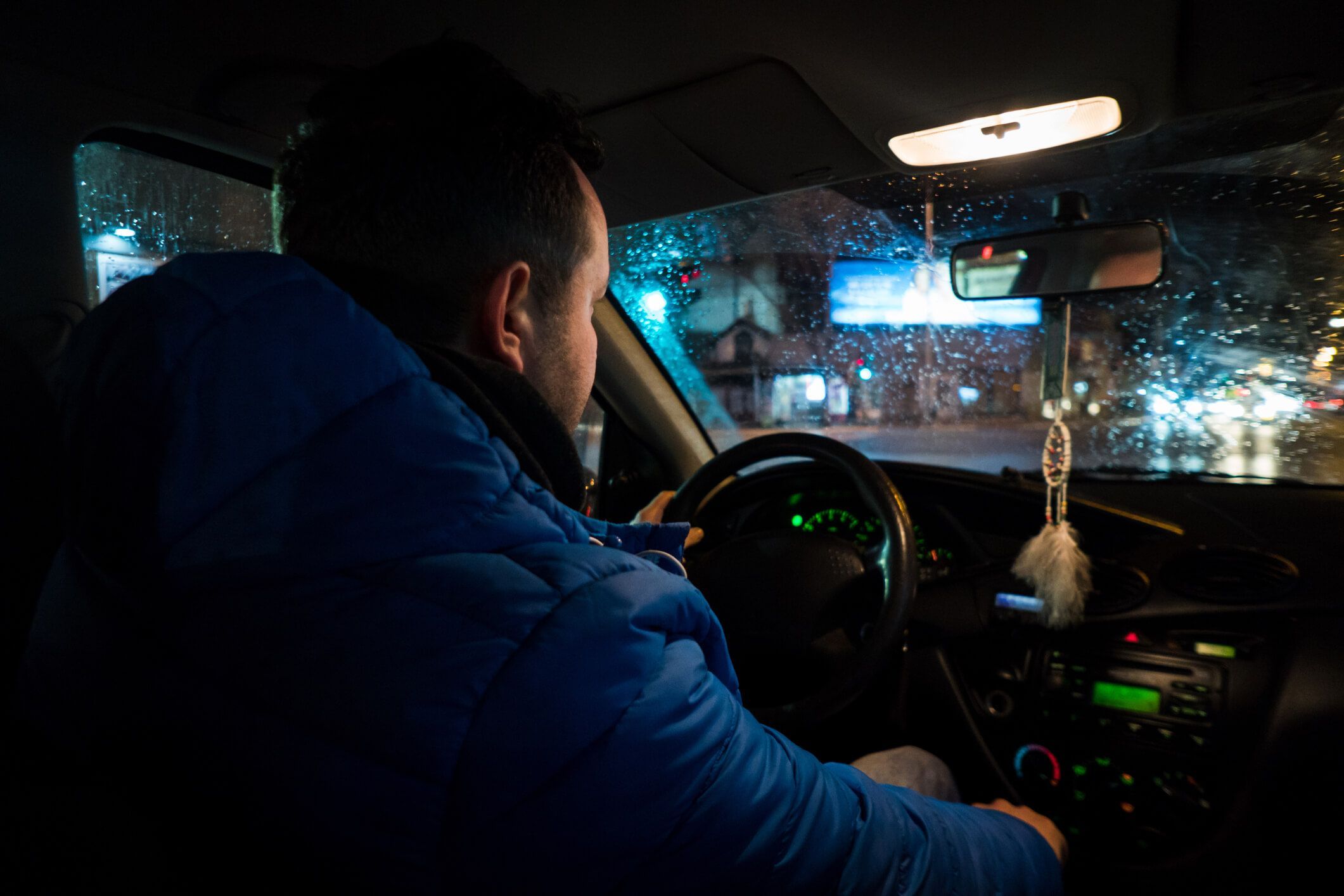 Junger Mann sitzt in Bus und fährt nachts.