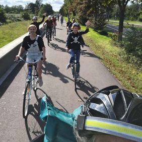 Mehrere Menschen fahren Fahrrad in einer Gruppe.