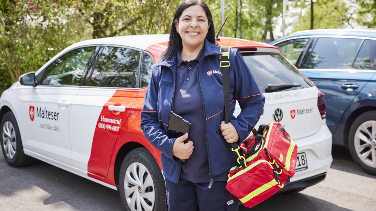 Malteser Hausnotruf Bereitschaftsdienstmitarbeiterin lächelt in die Kamera.