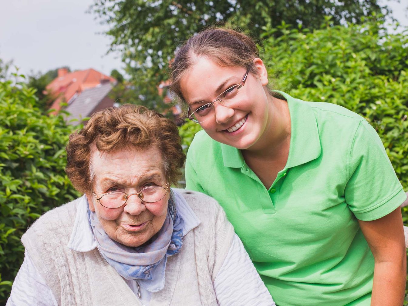 Pflegerin und Bewohnerin gemeinsam draußen an der frischen Luft 