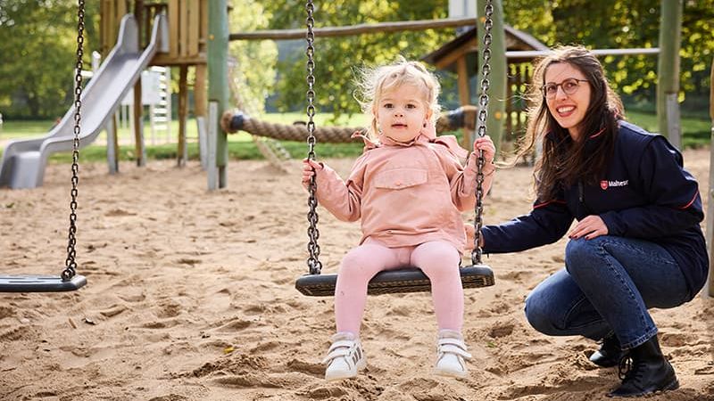 Malteser Trauerbegleiterin mit einem kleinen Mädchen auf dem Spielplatz