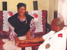 A care team worker speaks with a woman during a home visit.
