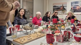 Mehrere Menschen sitzen um einen dekorierten Tisch und spielen Bingo