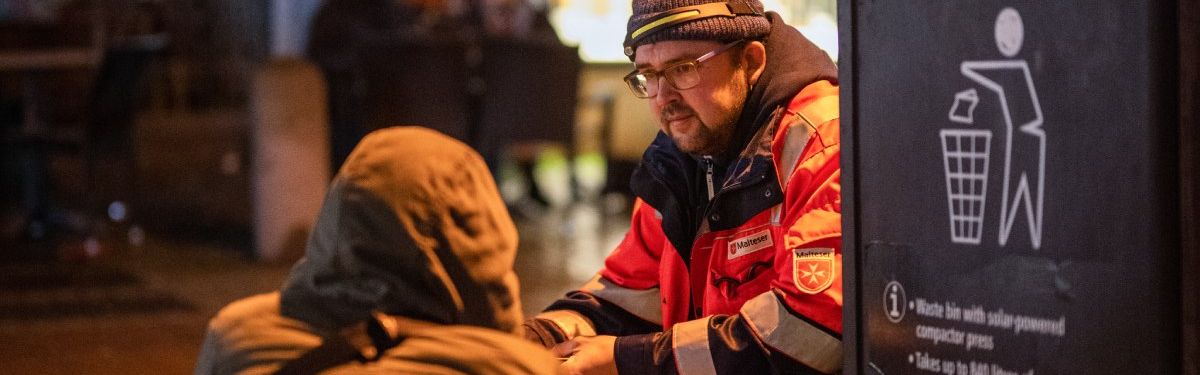 Zwei Männer knien auf einem Bürgersteig