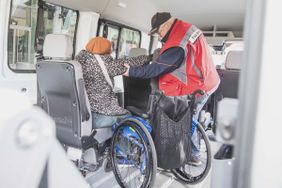 Eine Frau wird mit dem Fahrdienst transportiert