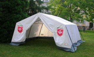 Bild vom einem aufgebauten SG50 mit zwei Malteser Wappen auf einer Wiese.