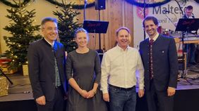 Drei Männer und eine Frau stehen auf einer Bühne.