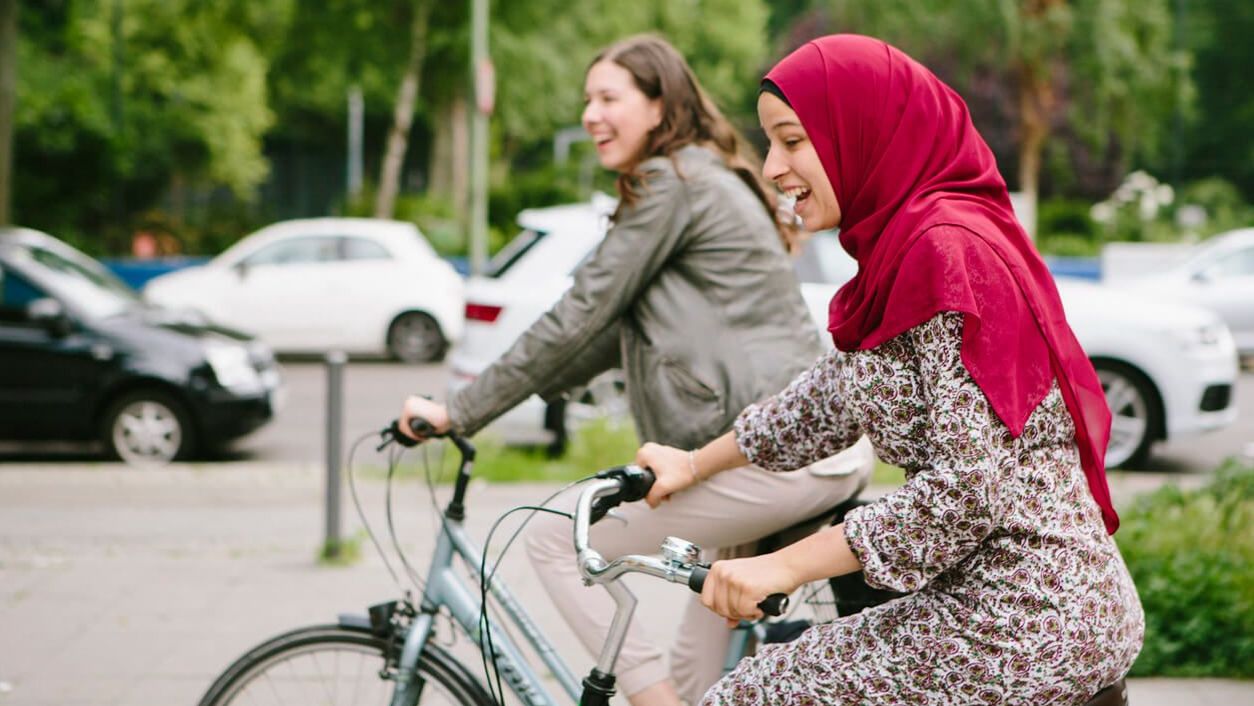 Bike Bridge: zwei junge Frauen fahren auf dem Fahrrad