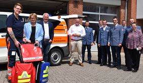 11 Frauen und Männer, Taschen und ein Fahrzeug