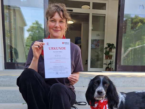 Hier ist ein Foto einer Absolventinnen der Weiterbildung des Besuchshundedienstes der Malteser Berlin zu sehen.
