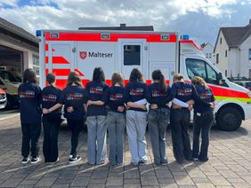 Schulsanitäter-Team vor dem Rettungswagen