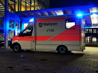 Malteser Krankenwagen vor Schulgebäude
