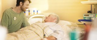 Mann besucht einen Patienten im Krankenhaus