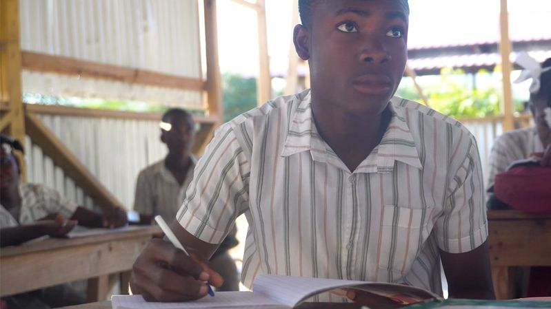 Eine Gruppe Schüler in einem offenen Klassenraum in Haiti