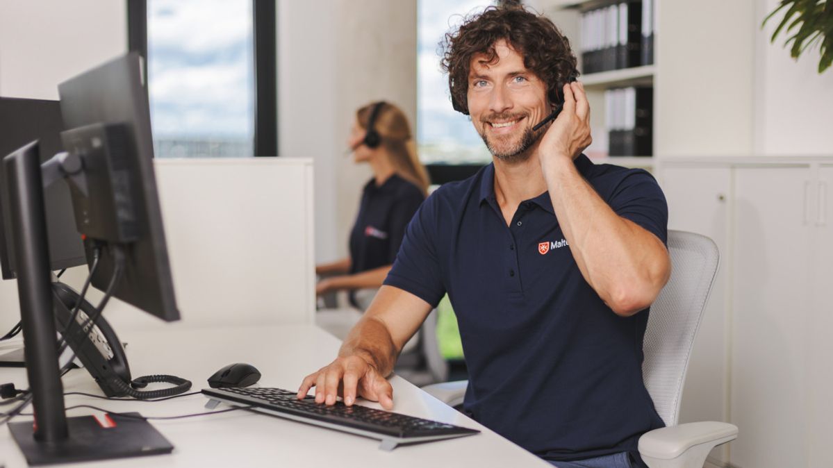 Malteser Mitarbeiter in der Hausnotrufzentrale nimmt einen Anruf an.