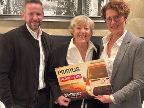 Zu Gunsten von „Malteser Herzenswunsch“ übergaben Daniel Brozowski (links) und Alexandra Michels (rechts) von der Primus-Geschäftsführung an Marie-Luise Marjan, Schirmherrin für das Jubiläumsjahr „10 Jahre Malteser Herzenswunsch Krankenwagen“, einen symbolischen Spendenscheck über 10.000 Euro.
