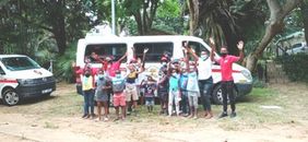 Kinder und Betreuer vor dem Kleinbus beim Bildungslager.