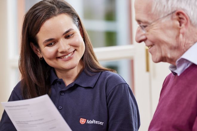 Eine Malteserin berät einen älteren Herren