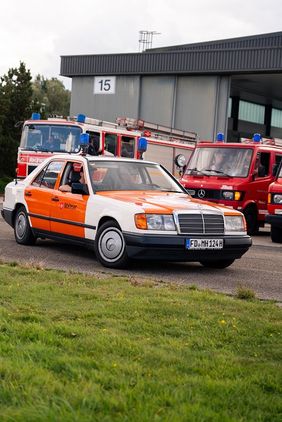 Ein Mercedes Oldtimer mit Blaulicht fährt über den Parkplatz