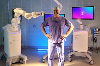 Arzt steht vor dem Wirbelsäulenroboter Medtronic Stealth AXiS™ in OP-Kleidung.