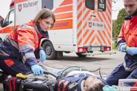 Zwei Einsatzkräfte im Rettungsdienst versorgen einen Patienten