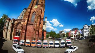 Malteser Fahrzeuge stehen auf dem Kirchplatz.