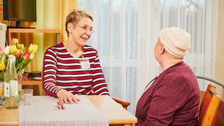 Gespräch am Tisch mit einer Patientin.