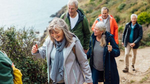 Eine Gruppe älterer Menschen wandern in Küstenlandschaft.