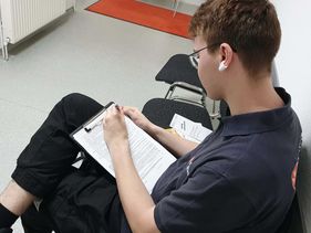 Ein junger Mann füllt einen Fragebogen aus.