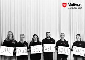 Lotsinnen und Lotsen der Malteser gemeinsam auf einem Postkartenmotiv.