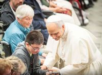 Der Papst im Kontakt mit einem Jungen, der im Rollstuhl sitzt