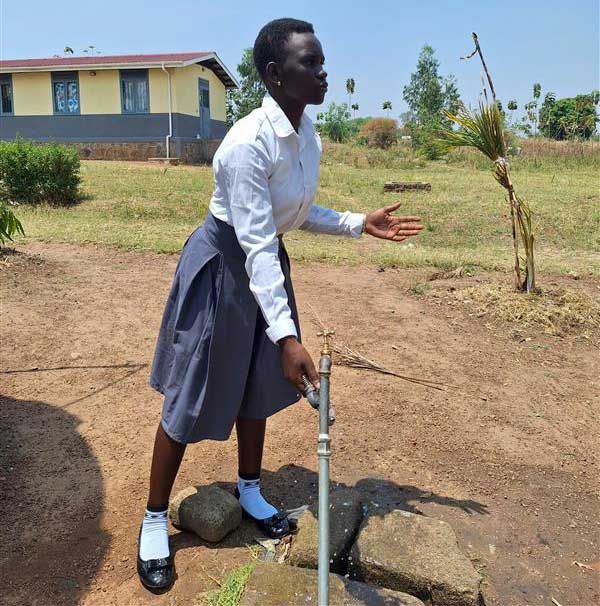 Eine Frau an einem Wasserhahn 