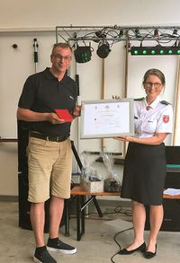 Der stellvertretende Diözesanleiter Matthias Geist (l.) nimmt die Verdiensturkunde und das Verdienstkreuz von Vizepräsidentin Clementine Perlitt entgegen (r.)