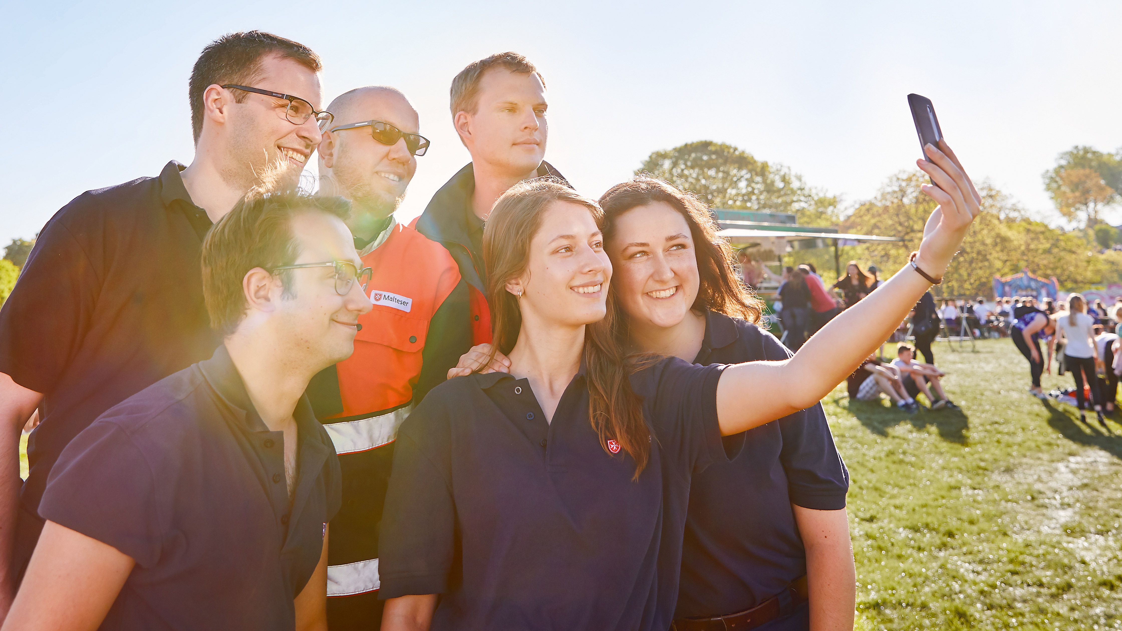 Foto von mehreren Personen aus den Einsatzdiensten, die gut gelaunt ein Selfie von sich machen.