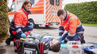 Eine Rettungssanitäterin und ein Rettungssanitäter versorgen einen Verletzten.
