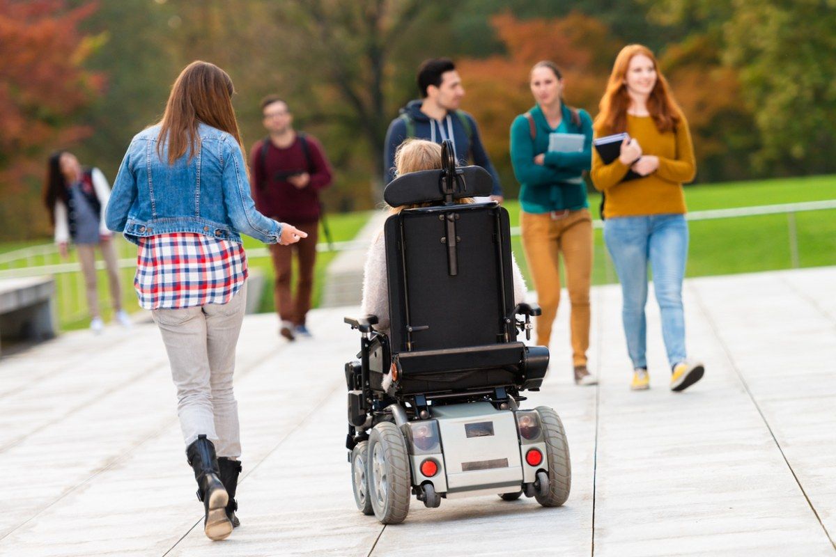 Junge Studierende, darunter eine Person im Rollstuhl