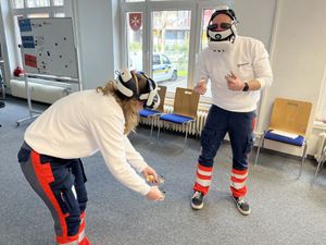 Zwei Azubis üben mit den aufgesetzten VR-Brillen die Handhabung in einem Ausbildungsraum der Malteser Dresden.
