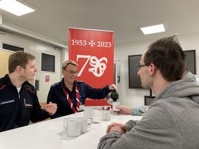 vier Menschen an einem Tisch trinken Kaffee