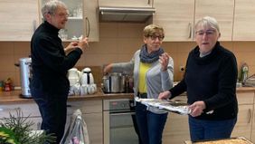 Drei Frauen bereiten in einer Küche Kuchen vor.