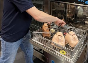 Ein Mann wäscht Gesichter aus Kunststoff