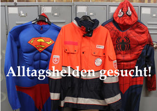 Superheldenkostüme und eine Einsatzjacke hängen an einem Spind. Alltagshelden gesucht!