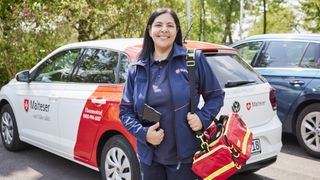 Malteser Hausnotruf Bereitschaftsdienstmitarbeiterin lächelt in die Kamera.