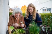 Eine ältere Frau und eine Mitarbeiterin der Malteser beim Gärtnern