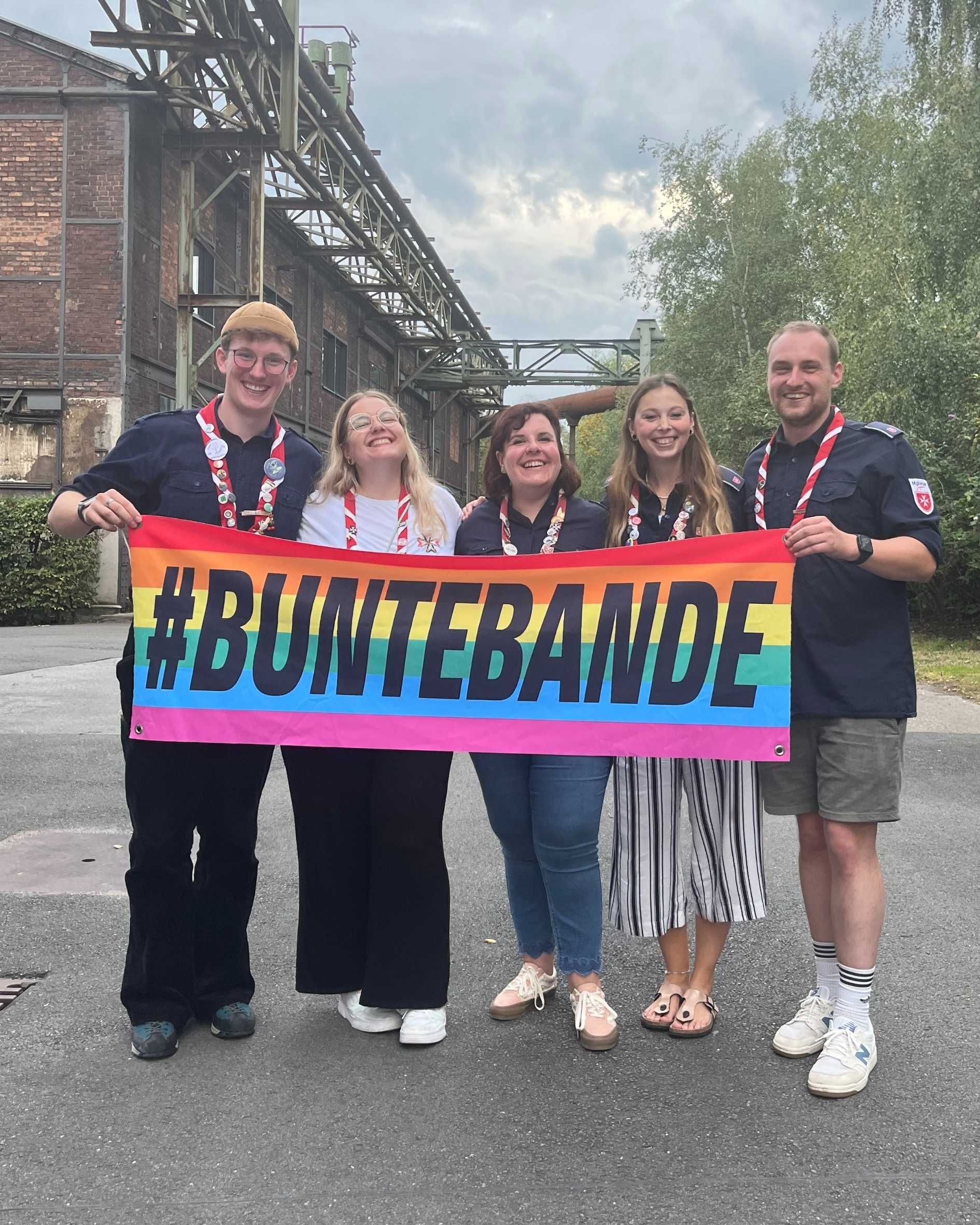 Der frisch gewählte Landesjugendführungskreis (LJFK) hält eine große Regenbogenflagge mit dem Schriftzug Hashtag Bunte Bande vor sich